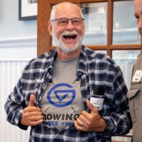 Man smiles as he shows off his rowing t-shirt